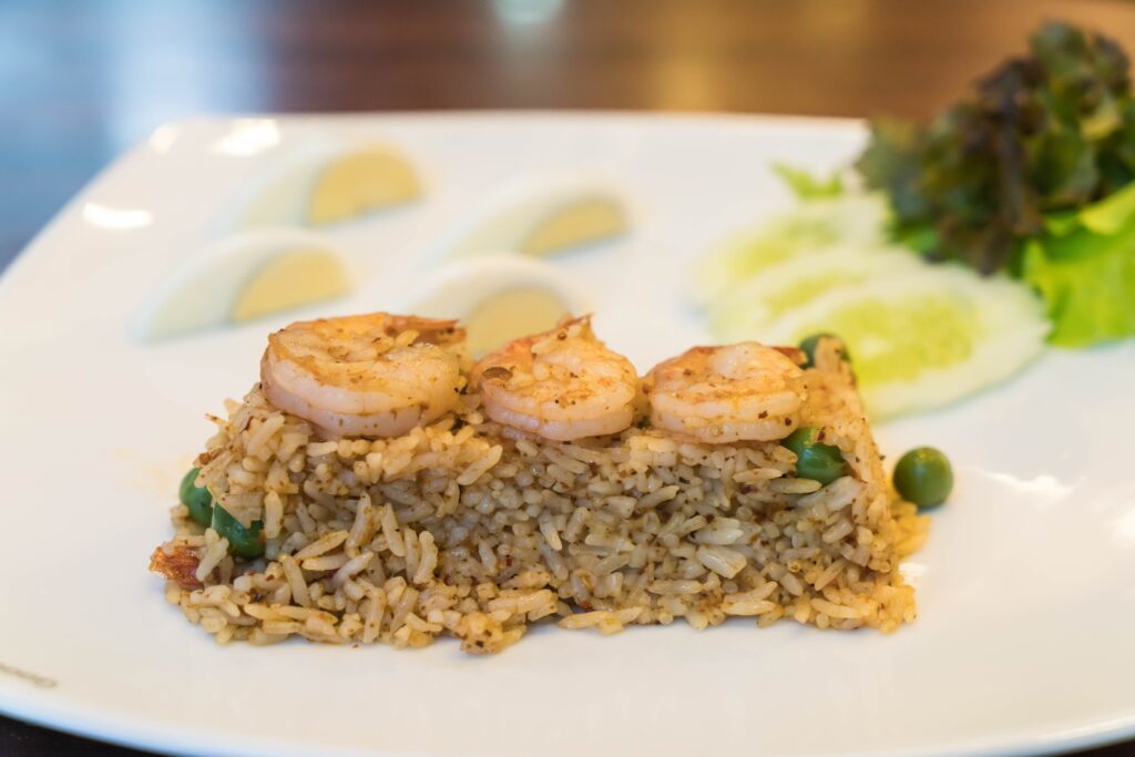 Fresh sea scallops being patted dry with a paper towel on a plate.