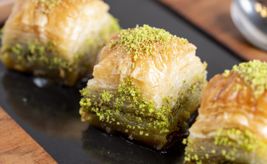 A close-up view of a plate of pistachio baklava,