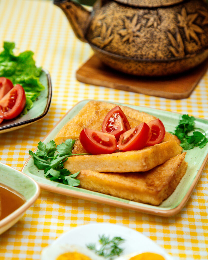 Golden brown cheesy hash browns served on a white plate with a garnish of fresh parsley